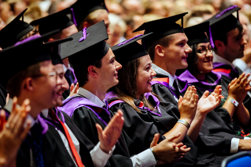 Graduates at their ceremony clapping happily